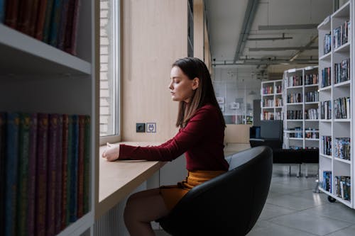 Side View of a Female Teenager Sitting on a Black Chair