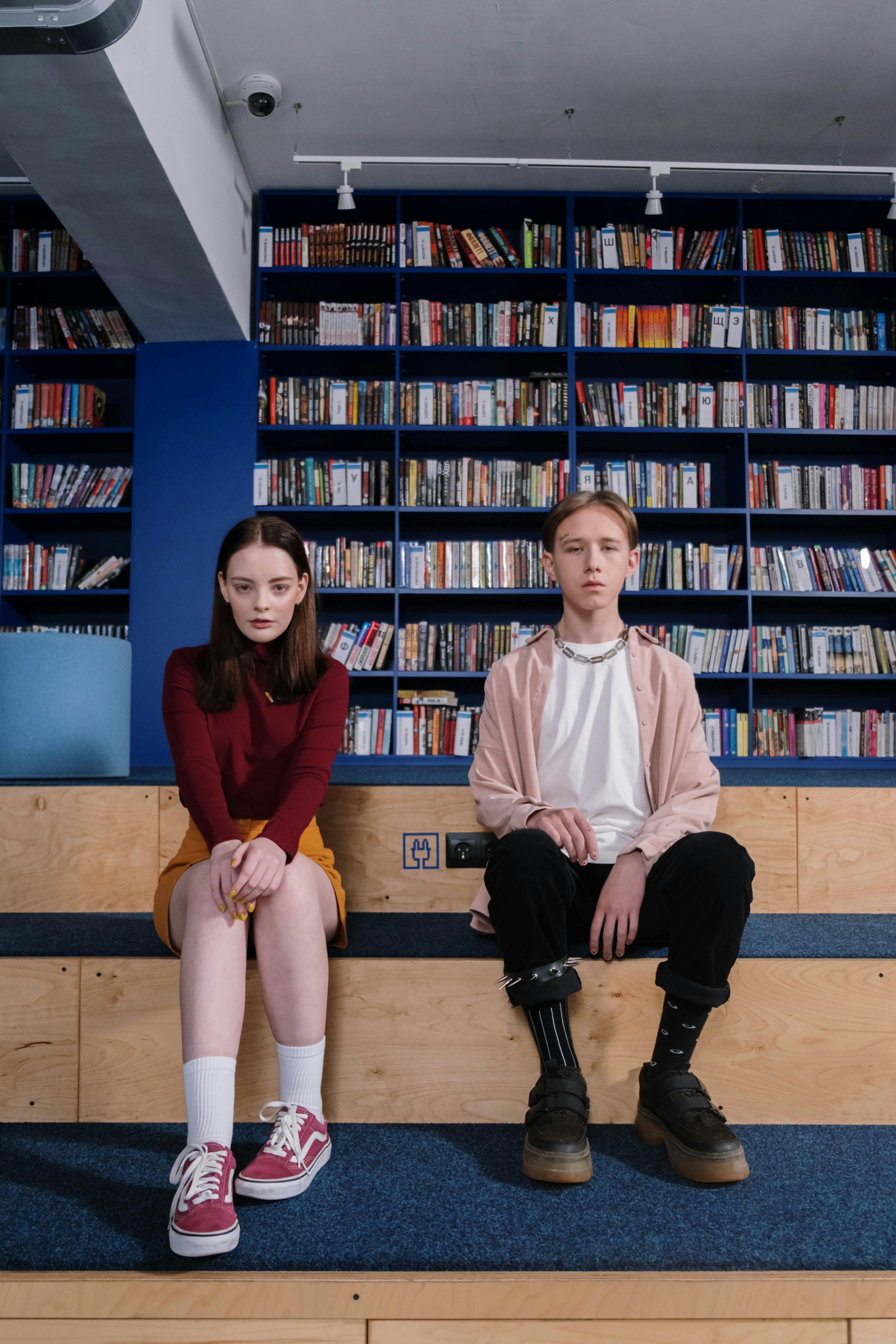 two teenagers sitting inside the library