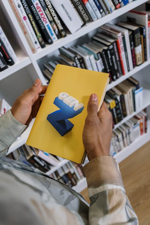 Free Close-Up Shot of a Person Holding a Yellow Book Stock Photo