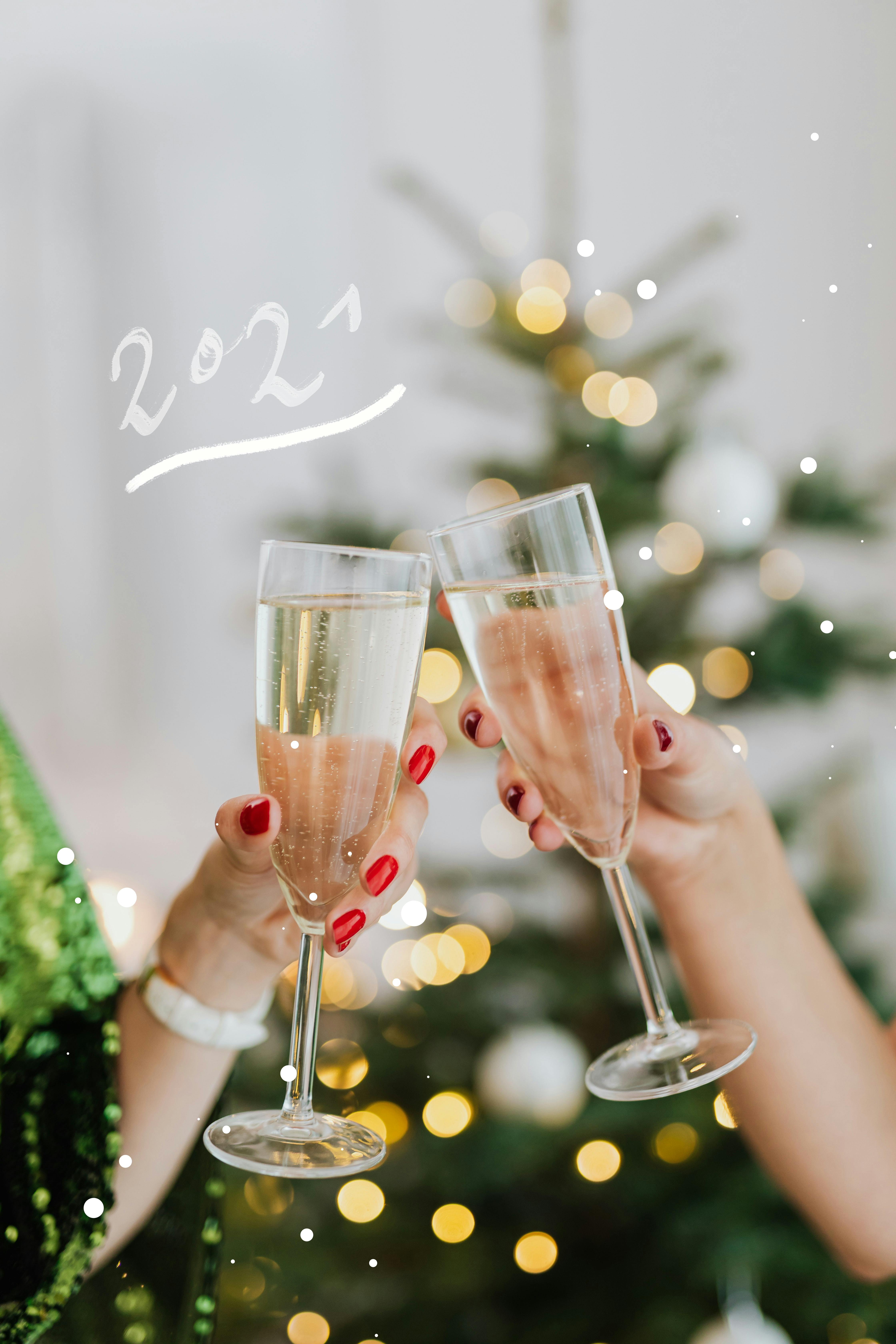 close up shot of a two people holding glasses of white wine