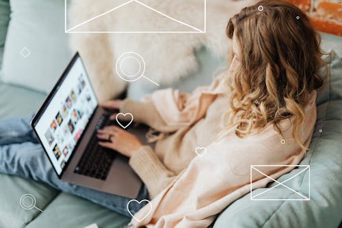 Free A Woman in Beige Sweater Sitting on a Sofa while Using a Laptop Stock Photo