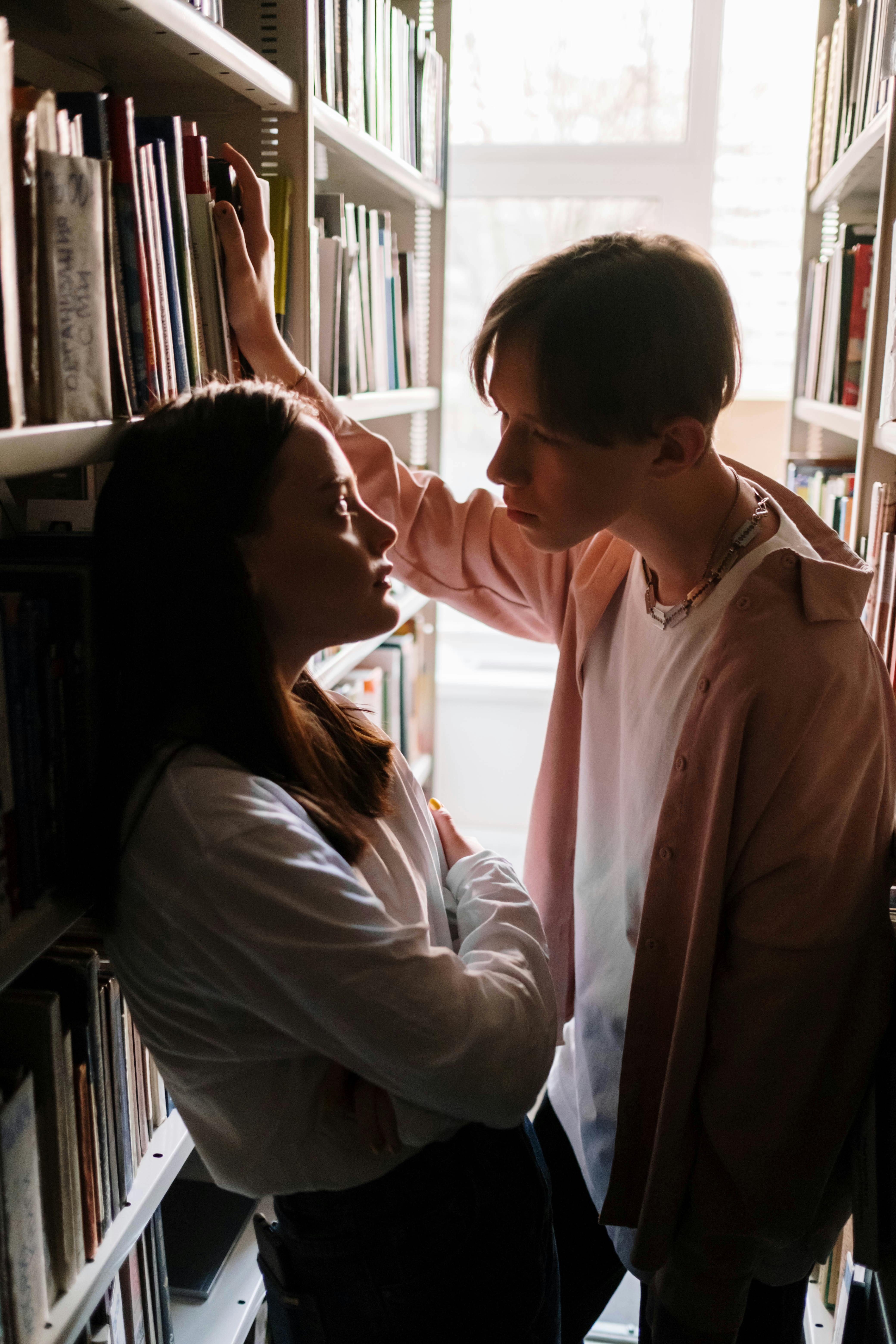 teen couple together in library