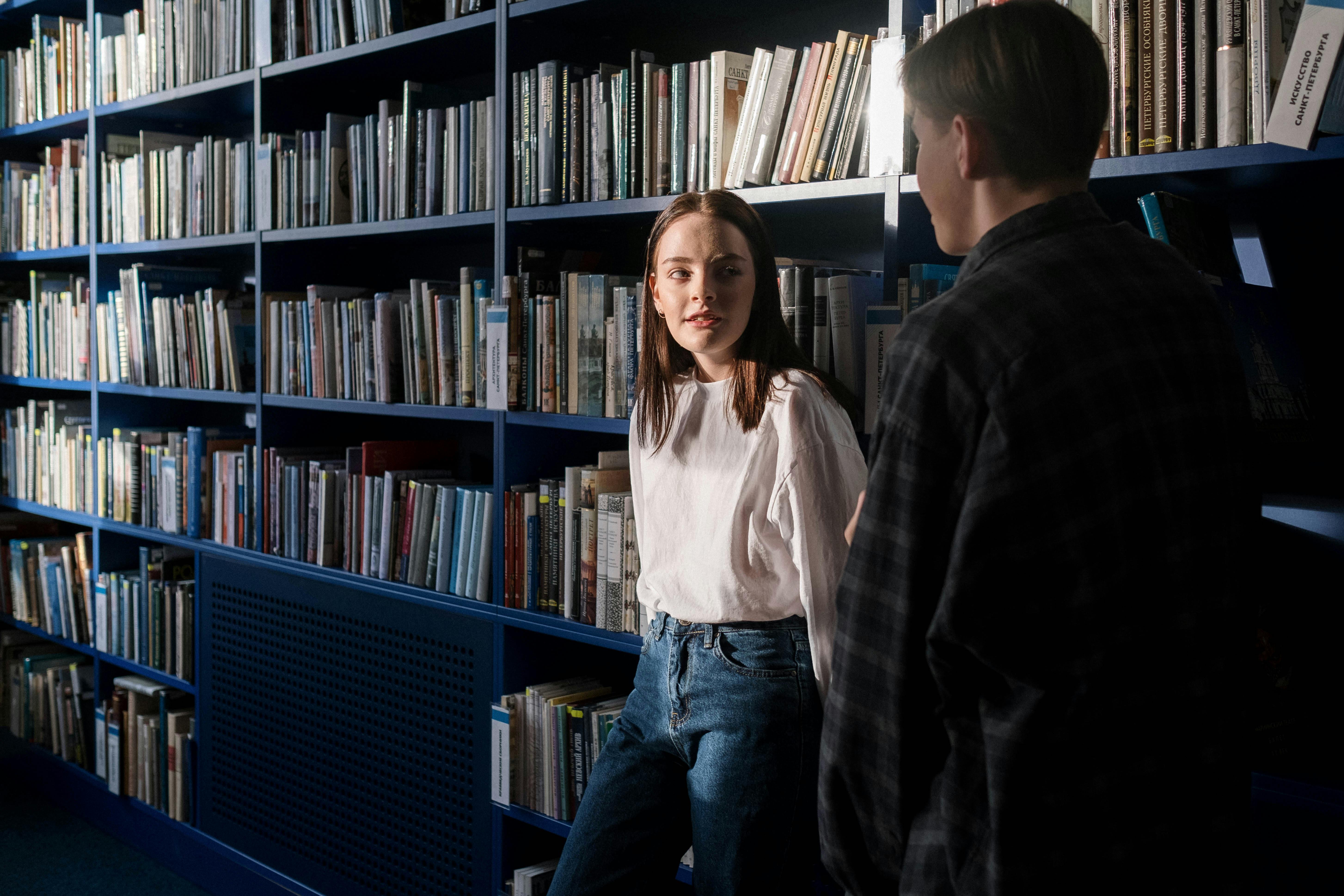 two students talking inside the library