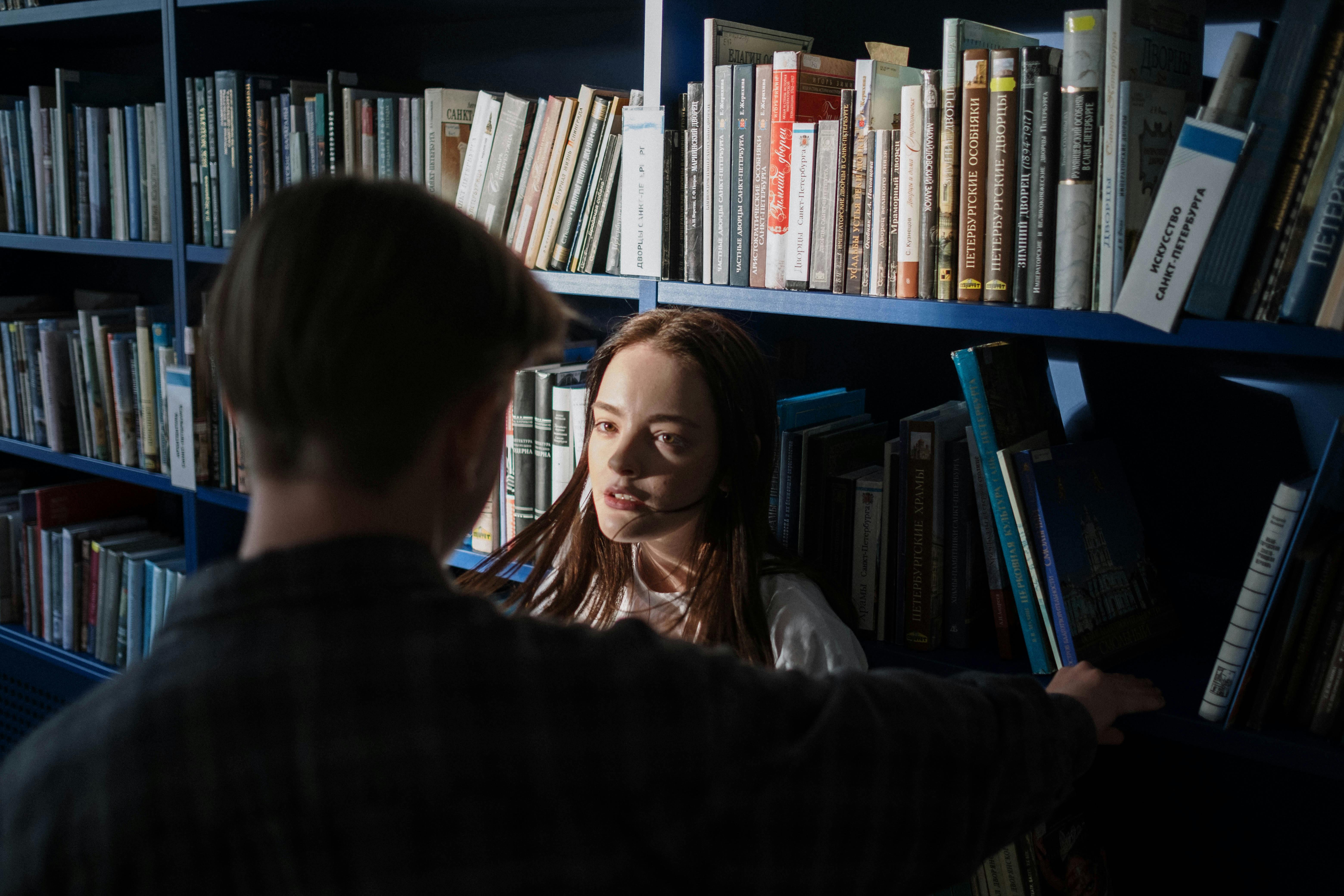 two students talking inside the library