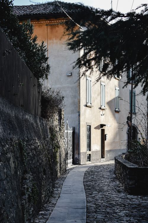 Free Peaceful cobblestone path through historic buildings in Bergamo, Italy. Stock Photo