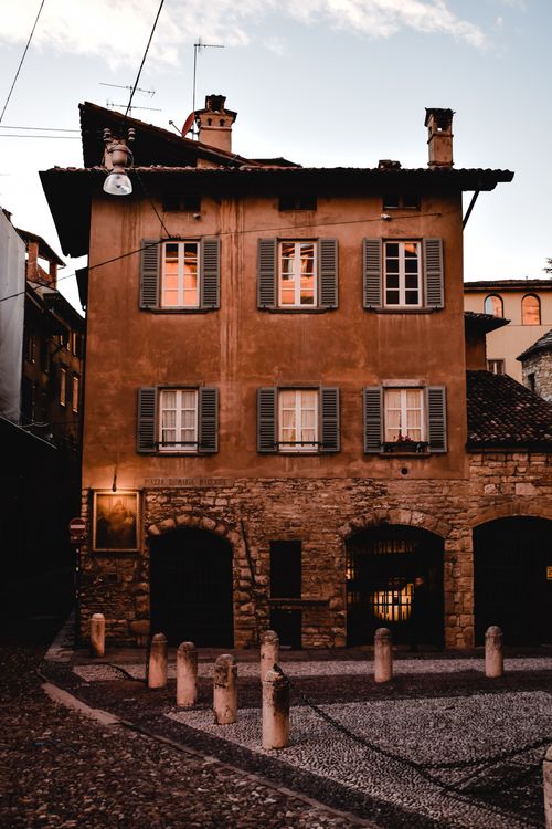 Free Warm evening light casts over a quaint building facade in Bergamo, showcasing historic European architecture. Stock Photo