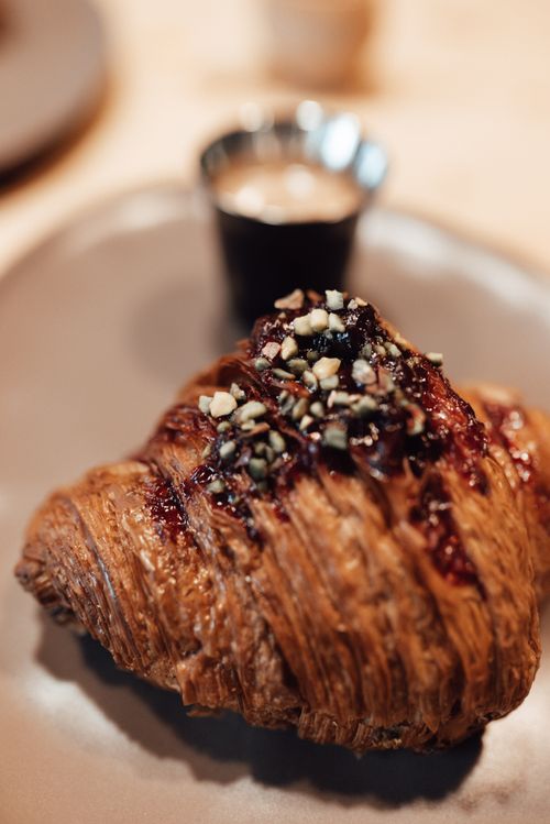 Free Appetizing fresh baked croissant with chocolate placed near small cup of expresso in cafe in daylight Stock Photo