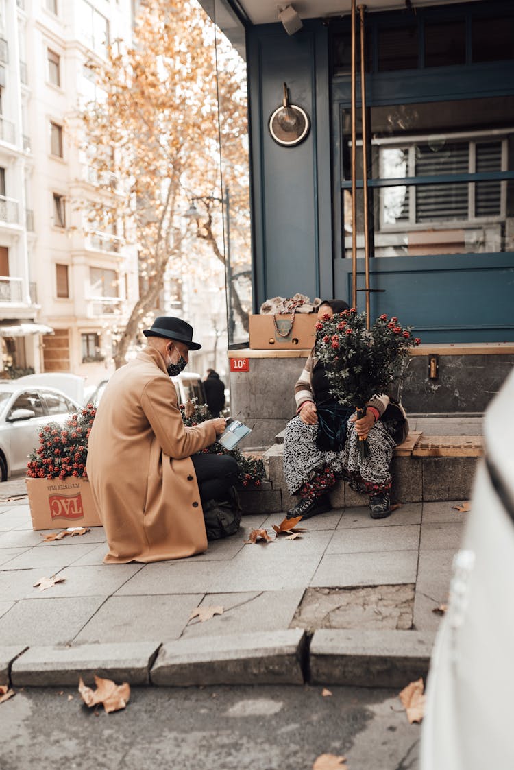 Anonymous Woman Selling Flowers To Man