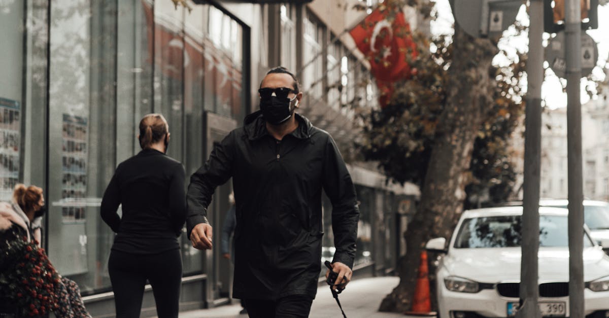 People walking along sidewalk near building in city