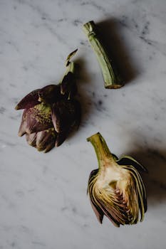 Flat lay of organic artichokes on marble, perfect for healthy eating concepts.