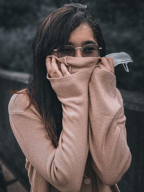 A Woman in a Sweater Covering Her Face