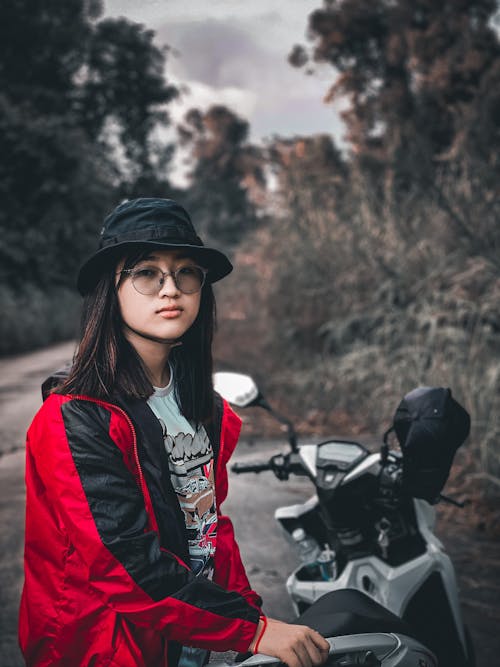 
A Woman Wearing a Hat and a Red and Black Jacket