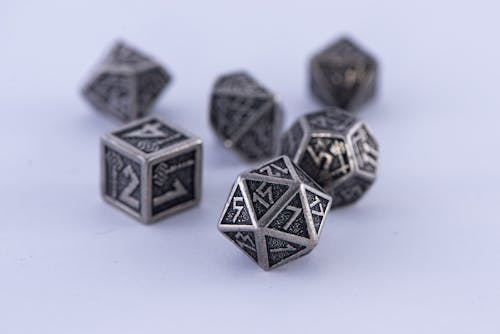 Close-Up Shot of Mythical Dice on a White Surface