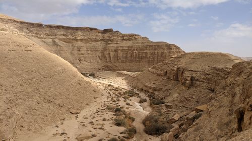 Free A breathtaking view of an arid desert canyon under a clear blue sky, showcasing nature's raw beauty. Stock Photo