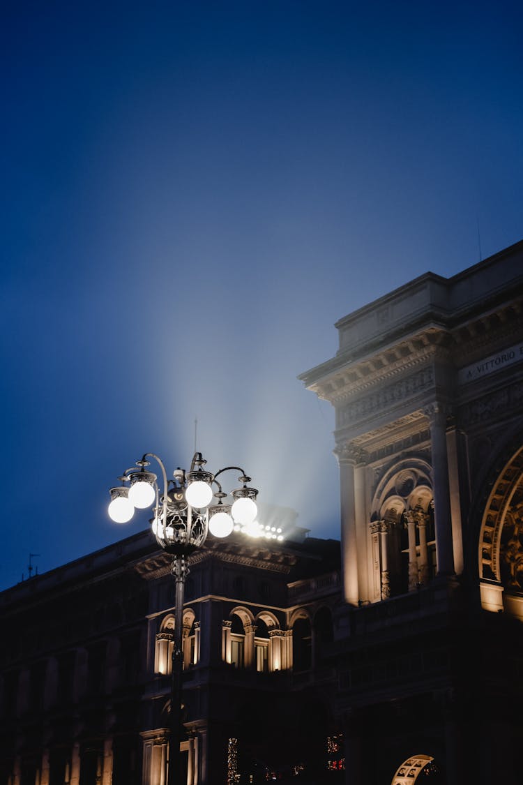 Lit Street Lamp Near The Buildings At Night