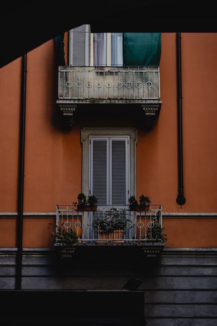 Stunning view of a classic Italian balcony adorned with potted plants in Milan.