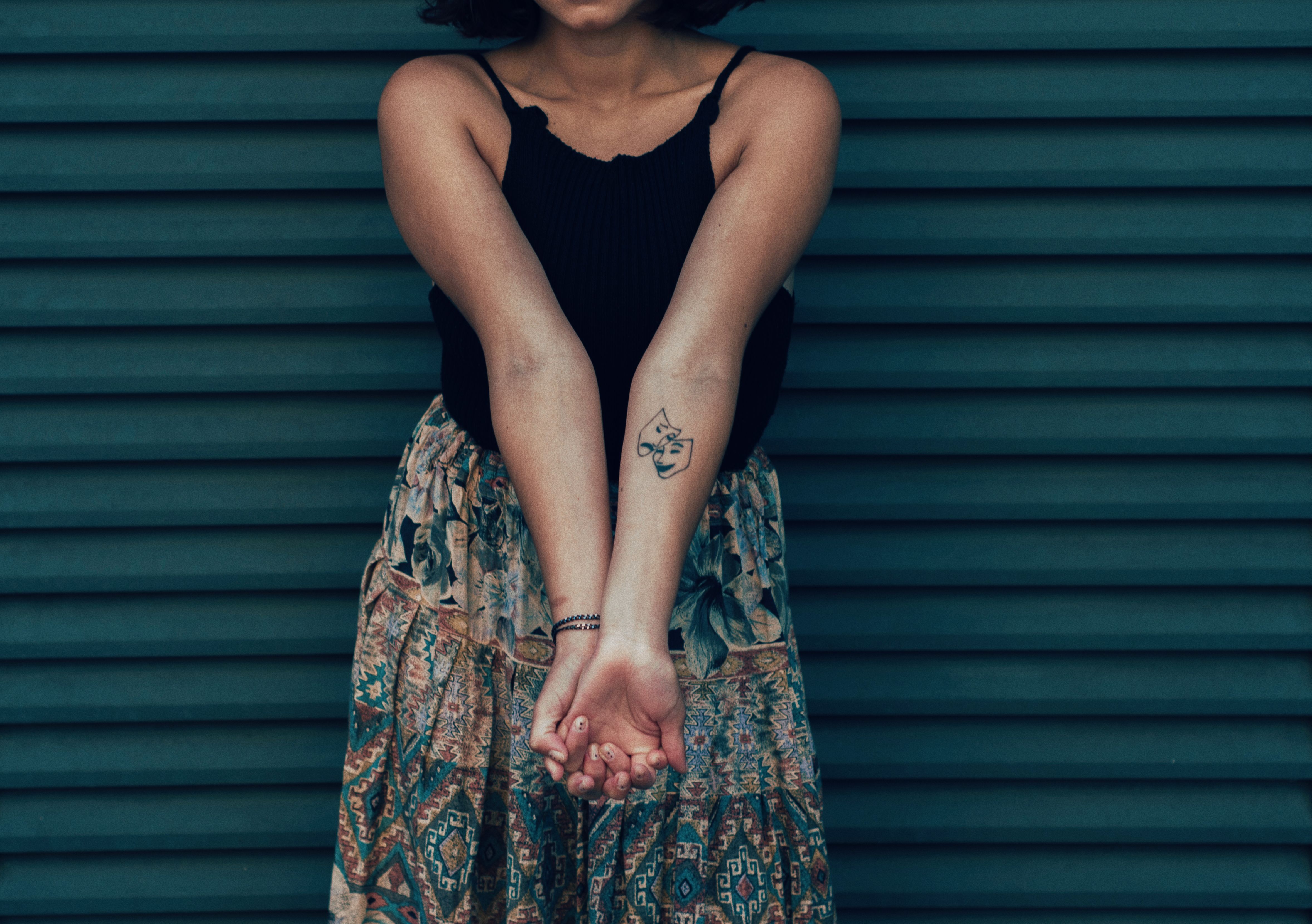 Woman showing a small delicate wrist tattoo, styled for everyday wear