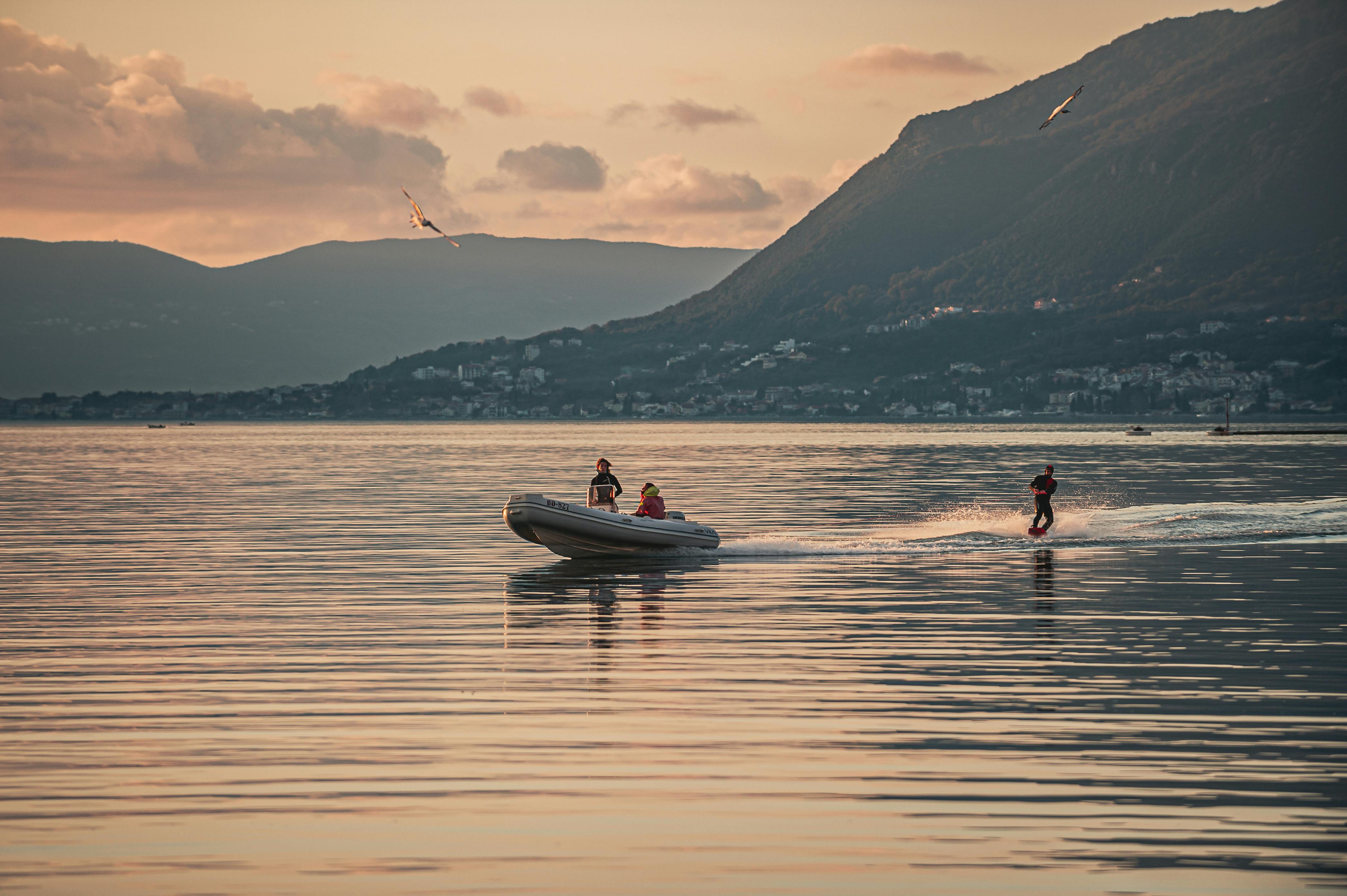 Prescription Goggle Inserts - People enjoying wakesurfing behind a speedboat at sunset in Tivat, Montenegro.