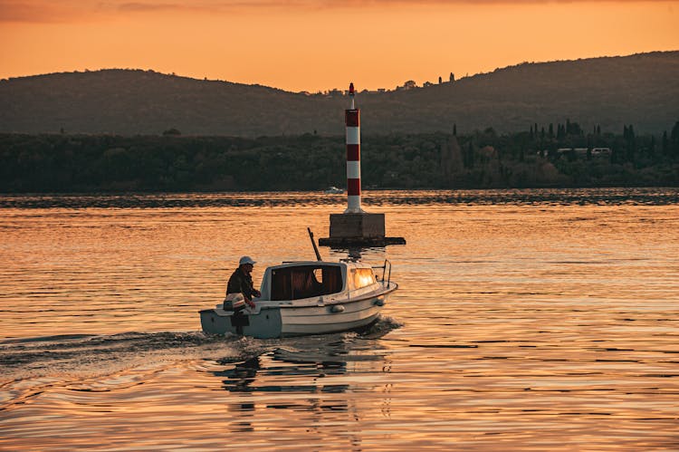 A Person Riding On A Speedboat During Sunset