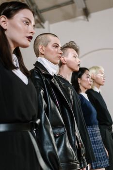 A diverse group of Gen Z individuals displaying unique fashion styles in a modern indoor setting.