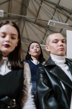 A group of fashionable Gen Z friends standing indoors showcasing diverse style and confidence.