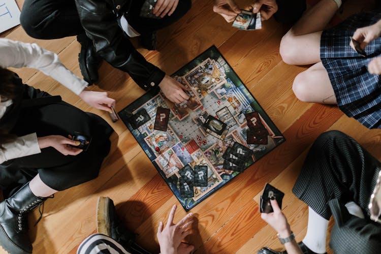 Overhead Shot Of A Group Of People Playing A Board Game