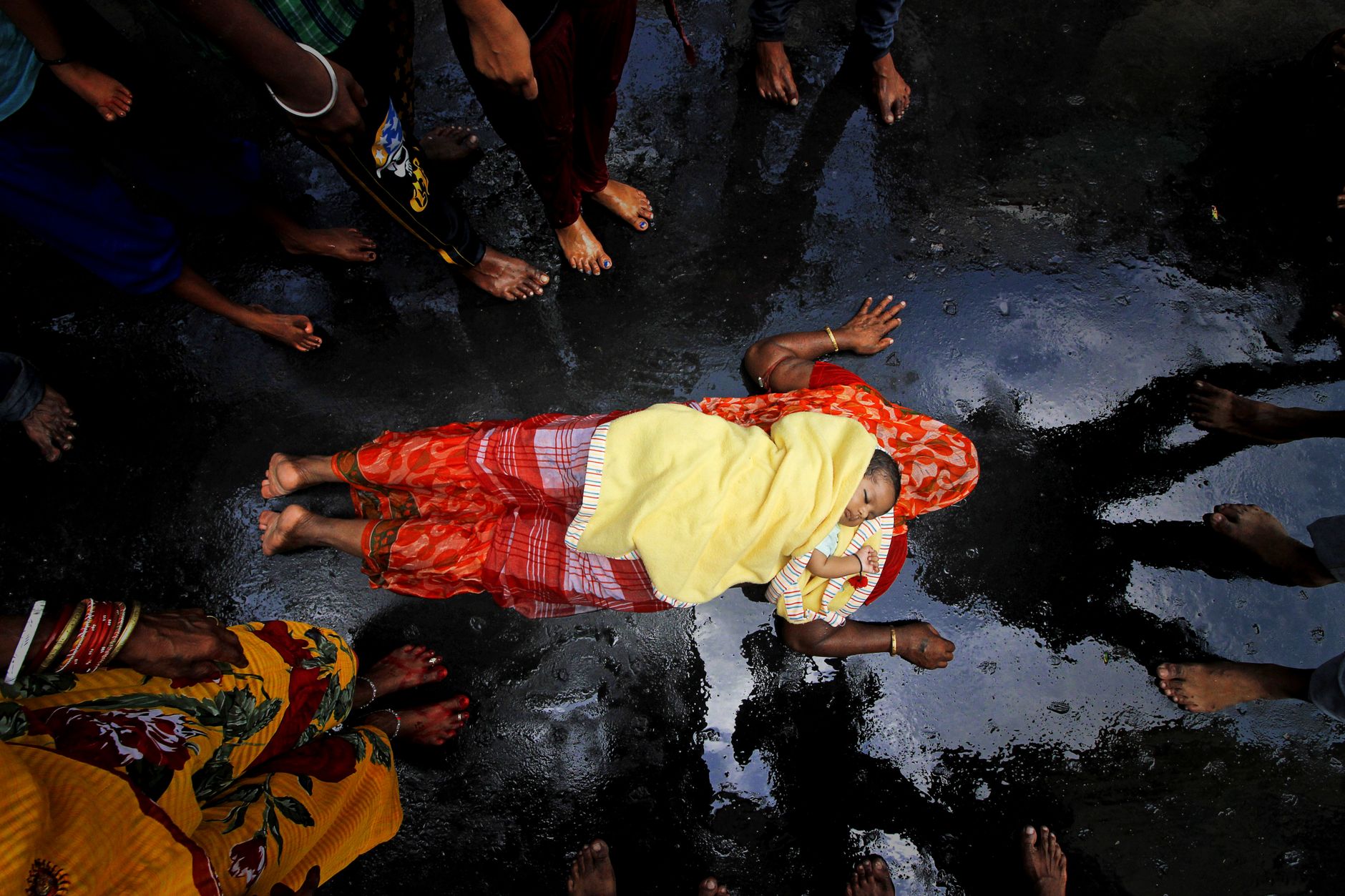 A mother and her child participate in a vibrant traditional ceremony in Kolkata, India.