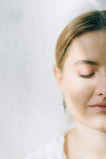 A serene close-up portrait of a woman with closed eyes bathed in gentle light.