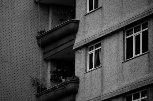 Free Black and white photo of an urban building featuring balconies and windows in a detailed architectural style. Stock Photo