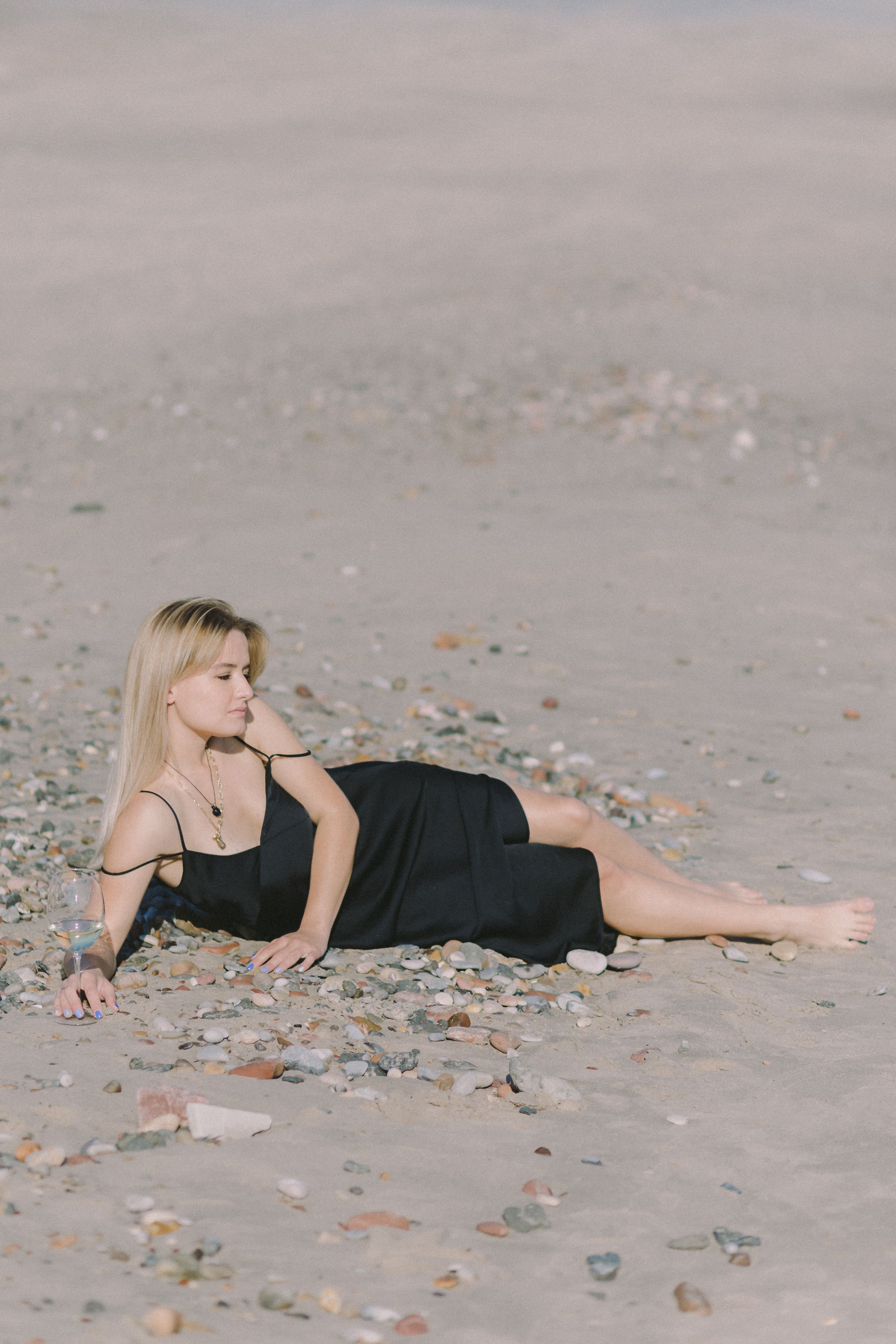 Woman in Black Dress Lying on the Beach · Free Stock Photo