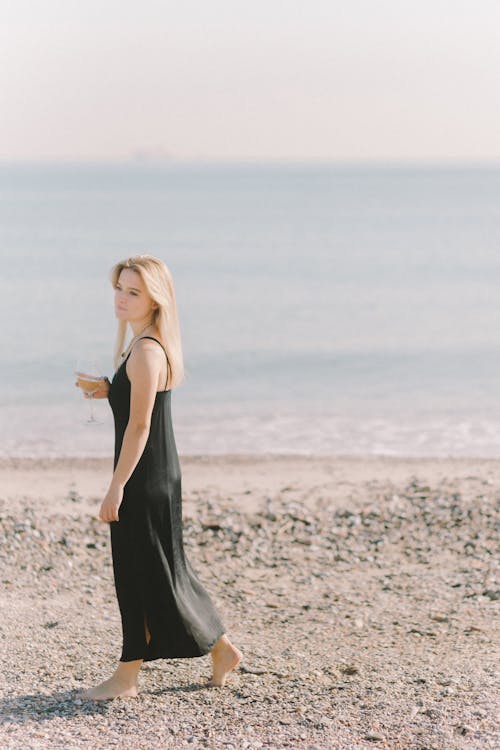 Blond Woman in Black Dress at the Beach