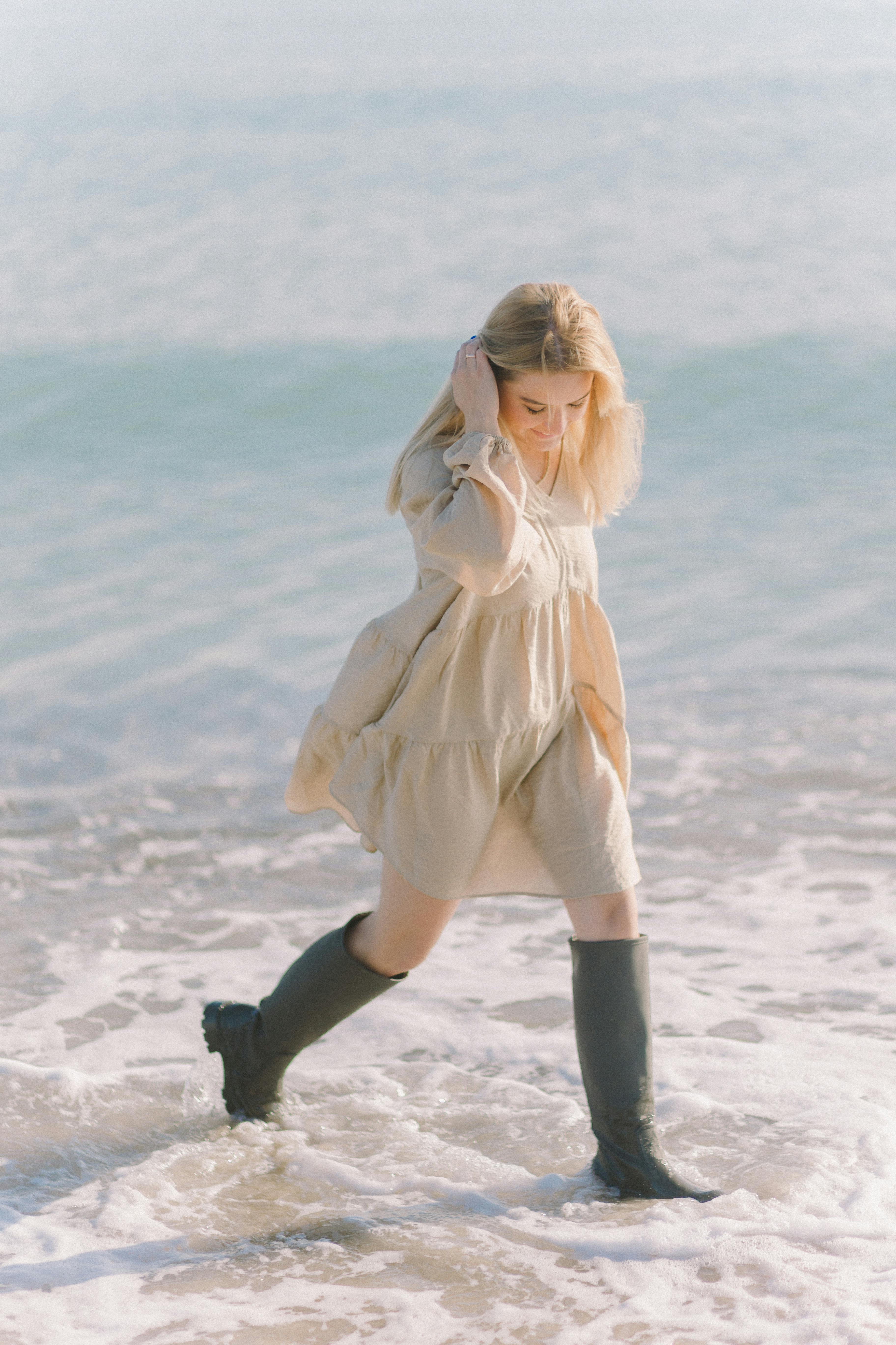 Woman in Beige Long Sleeve Dress Wearing Black Boots  Free Stock Photo