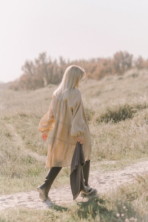 Free Woman walking on Dirt Path on Green Grass Field Stock Photo
