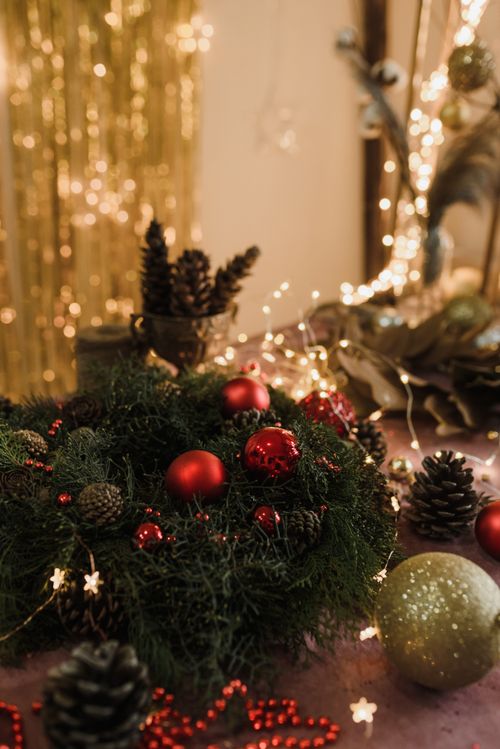 Free Warm and cozy Christmas decor with a wreath, baubles, and fairy lights, perfect for holiday season ambiance. Stock Photo