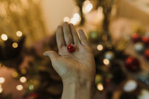 Person Holding a Small Christmas Ball