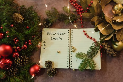 Free Spiral notebook with New Year goals amidst holiday decorations and Christmas ornaments. Stock Photo
