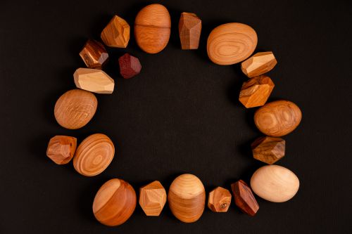 Free Styled flat lay of various wooden geometric shapes on black background. Stock Photo