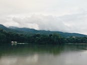 宁静的湖景、森林和山脉，倒映着云和平静的海水