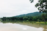 天空多云，宁静的湖泊和郁郁葱葱的山脉构成了一幅宁静的风景