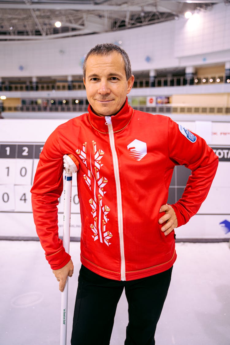 Man Standing Holding A Curling Broom