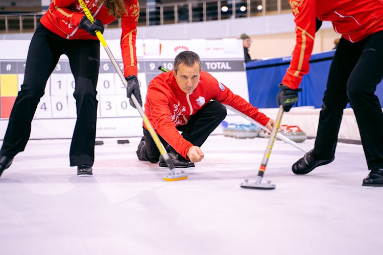 Man Playing Curling With Teammates