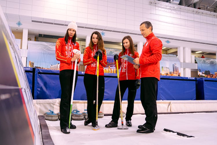 Curling Team Looking At The Results On The Board