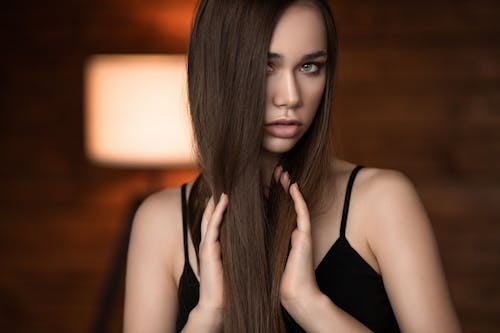 Free Crop woman with long hair against lamp Stock Photo