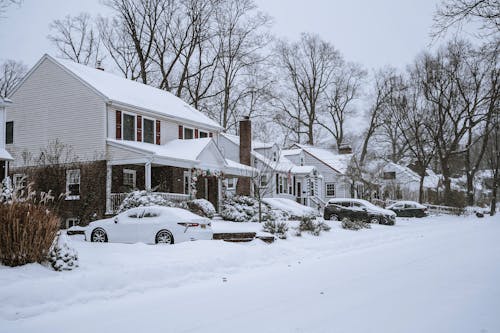 Houses with Parked Cars Covered in Snow