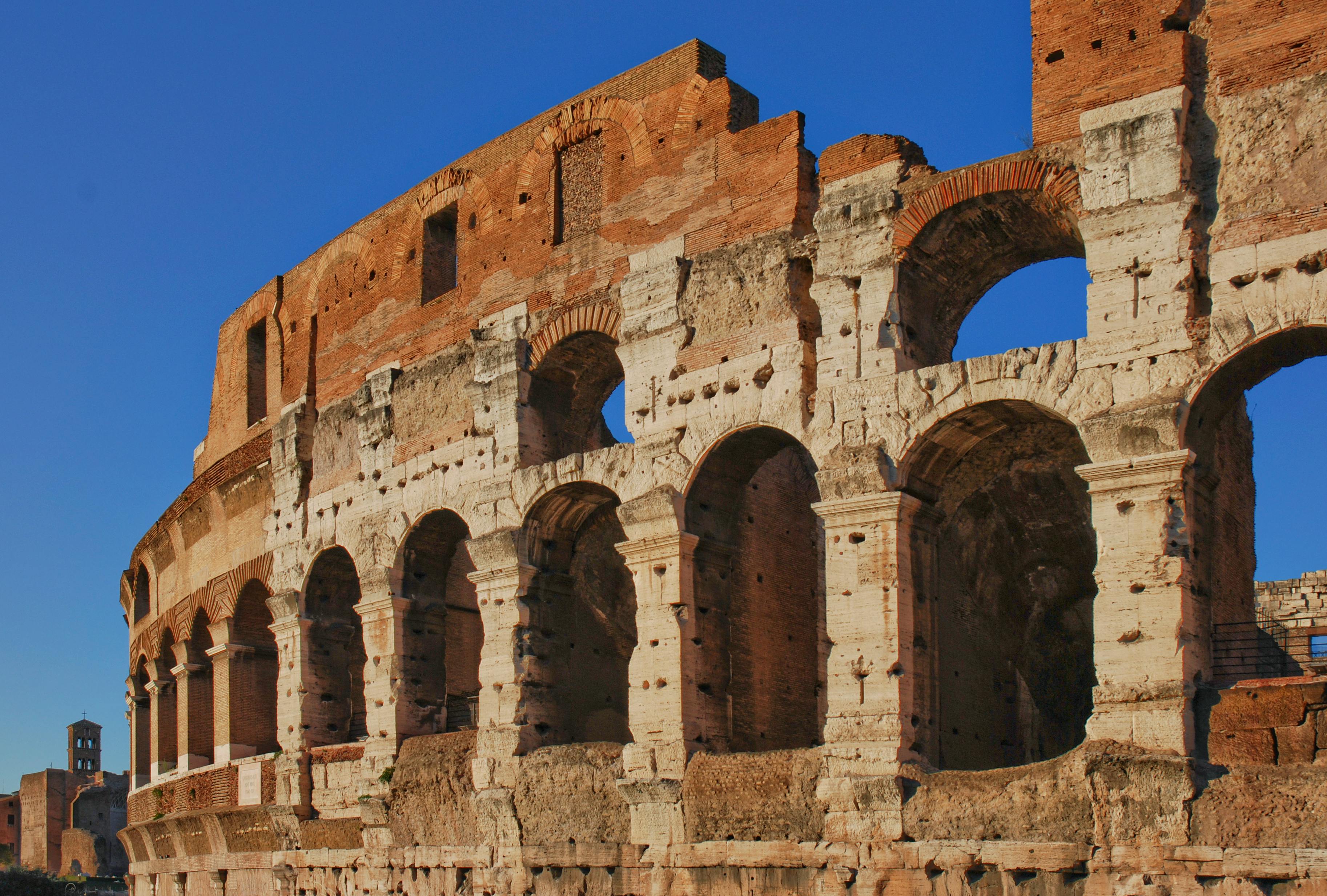 Free Stunning view of the Roman Colosseum, an iconic ancient landmark in Rome, Italy, under a clear blue sky. Stock Photo