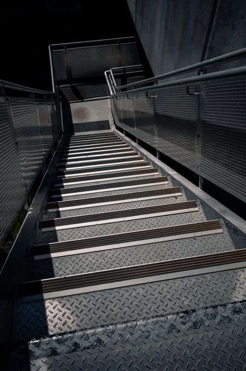 Free High-angle view of a modern steel staircase with railings, offering a geometric pattern in an outdoor urban setting. Stock Photo