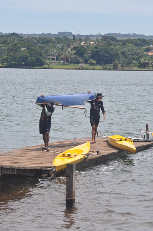 Men Carrying a Canoe on Wooden Dock