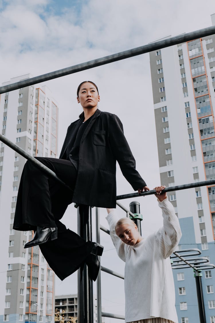 A Woman In Black Outfit Sitting On The Monkey Bars