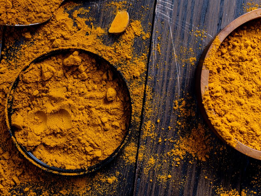 Bowls of turmeric powder on wood