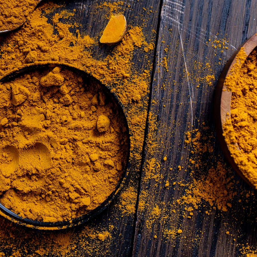Bowls of turmeric powder on wood